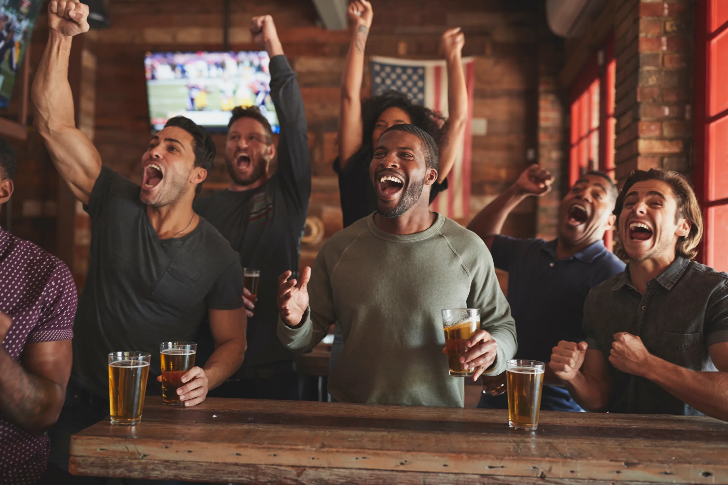 Sports fans cheering at a bar on game day